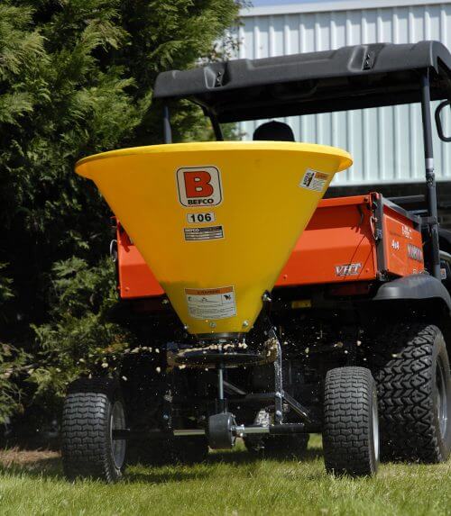 BEFCO Baby Hop Spreader yellow hopper, rear view, mounted on an orange utility vehicle.