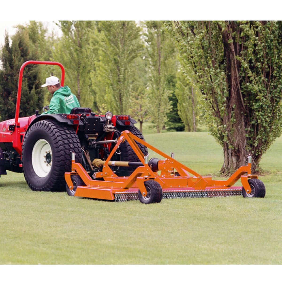 BEFCO C70 Grooming Mower angled view, orange with wheels and attached to a red tractor.