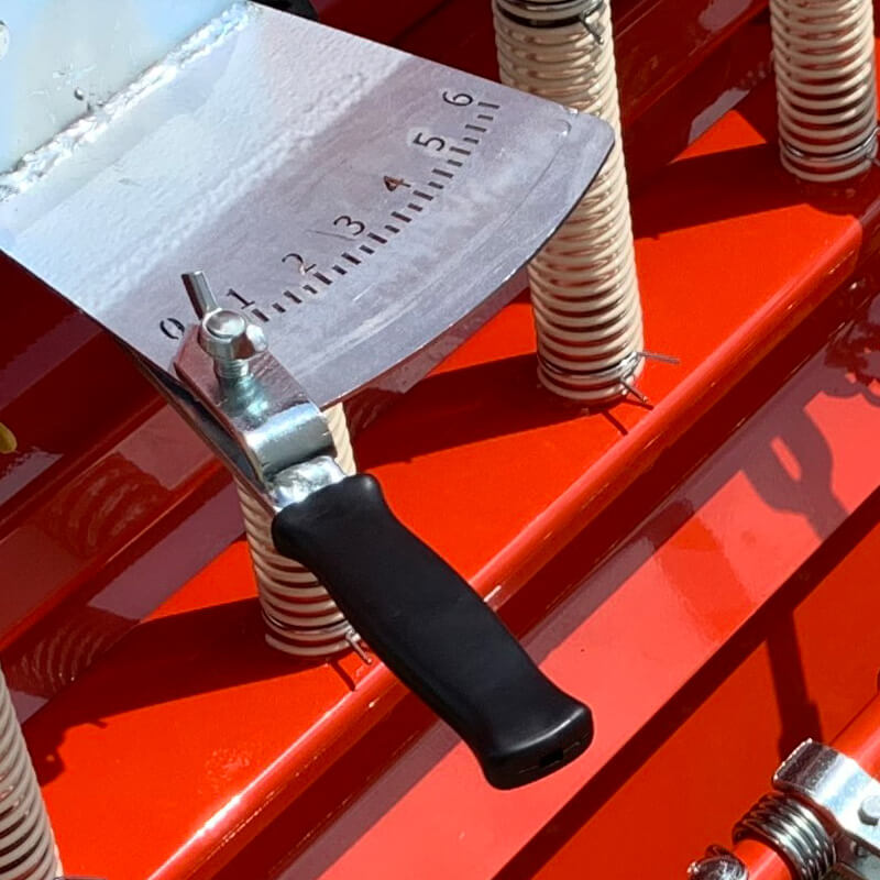BEFCO Green-Rite Seeder and Aerator angled view, red with measurement gauge and handle.