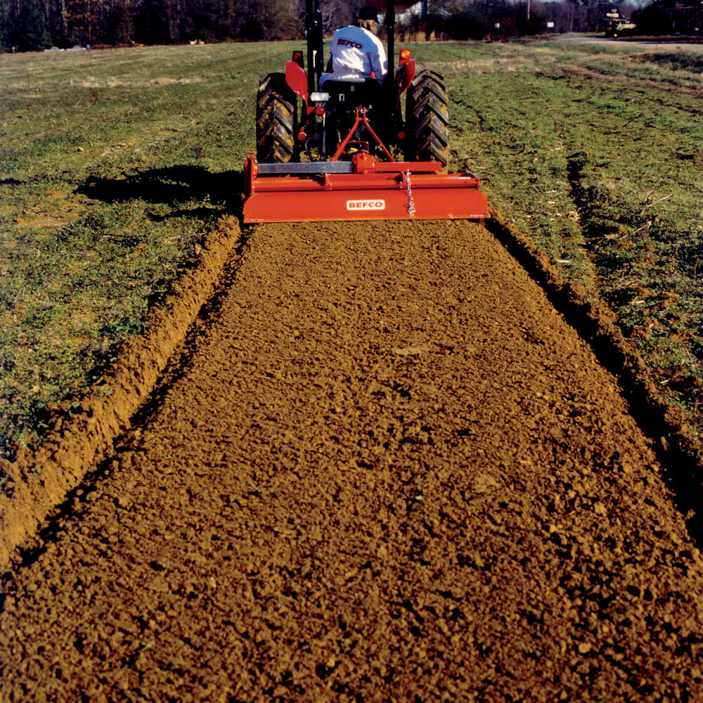 BEFCO T60 Rotary Tiller, rear view, red with tines for soil cultivation and agricultural use.