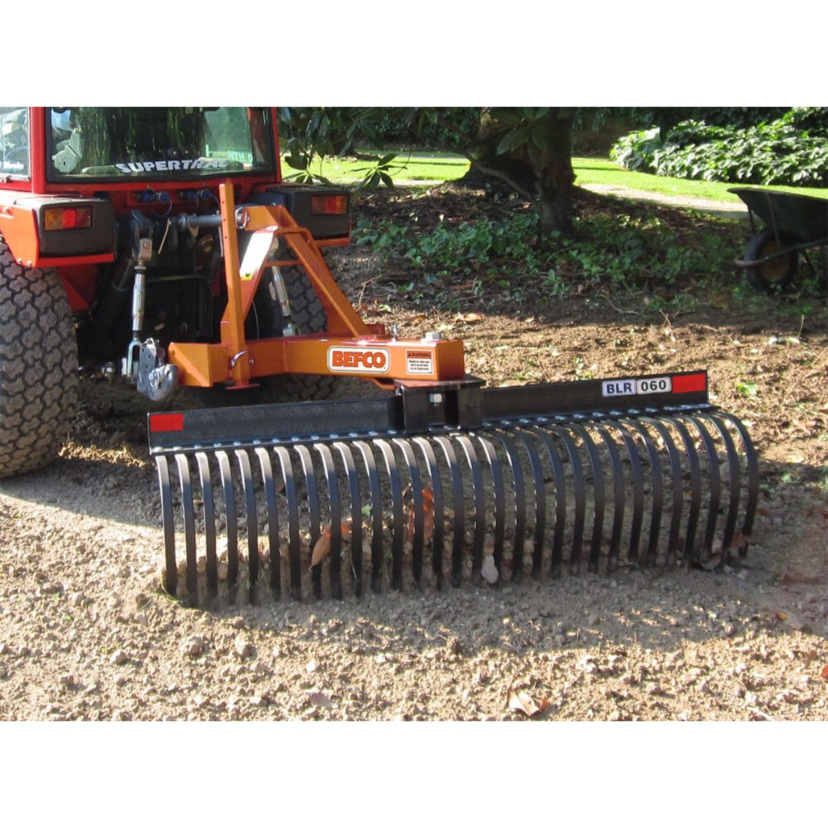 BEFCO Tractor Landscape Rake front view, orange with curved steel tines for efficient ground leveling.
