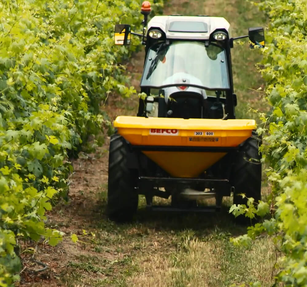 BEFCO Turbo Hop 303 Pendulum Spreader, yellow, angled view with large wheels for agricultural use.