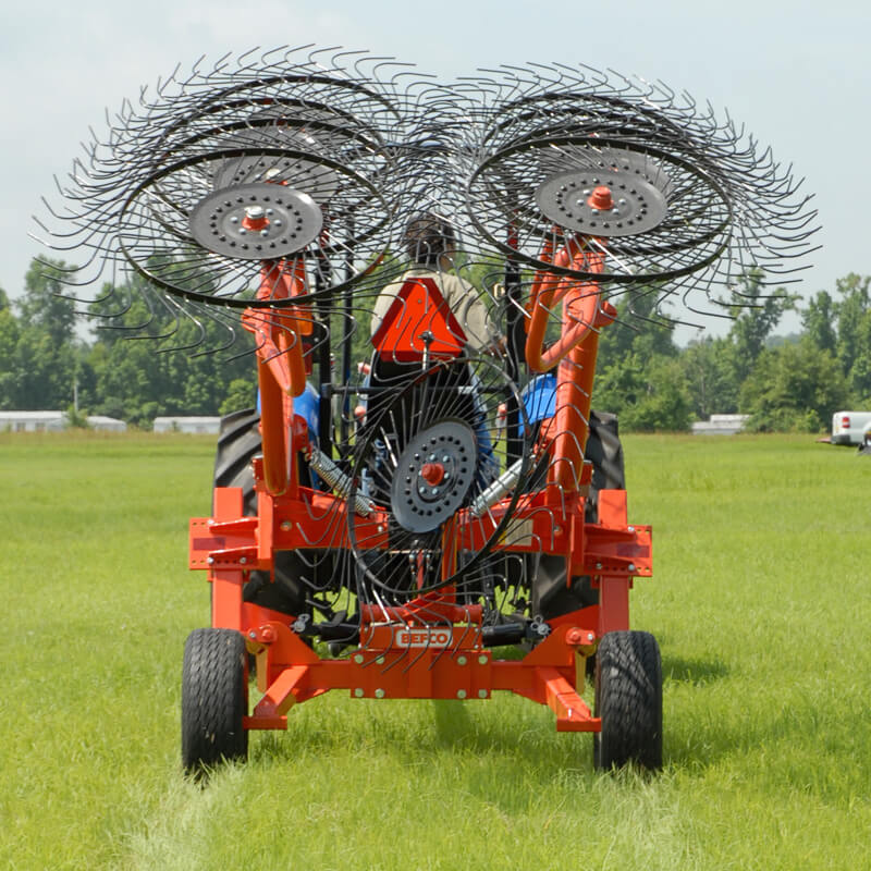 BEFCO Hay Rake, red, rear view with multiple rotating wheels and tines for efficient hay collection.