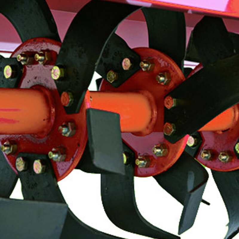 BEFCO T60 Rotary Tiller close-up, showcasing metal blades and orange axle components.