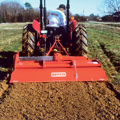 BEFCO T60 Rotary Tiller, red equipment viewed from the rear, features a sturdy tilling blade.