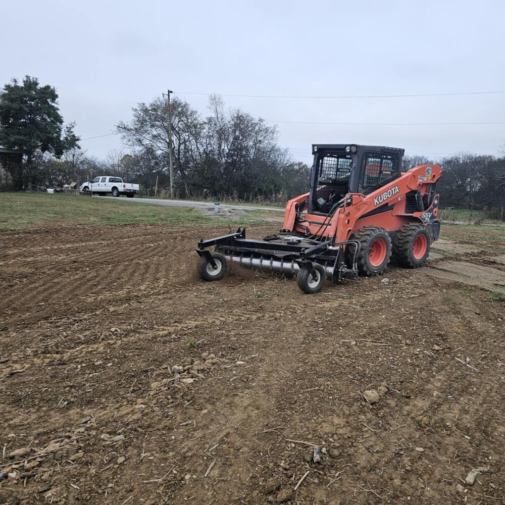 HD Soil Conditioner by Prime Attachments, angled view, orange with wheels and cutting blades.