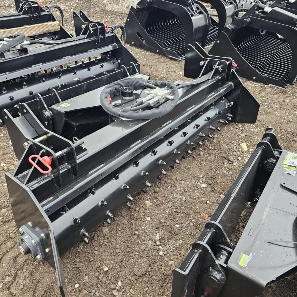 HD Soil Conditioner from Prime Attachments, black, angled view, features spikes and hydraulic connections.