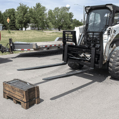 Prime Attachments Skid Steer Hydraulic Adjustable Forks, black, angled view with extended forks.