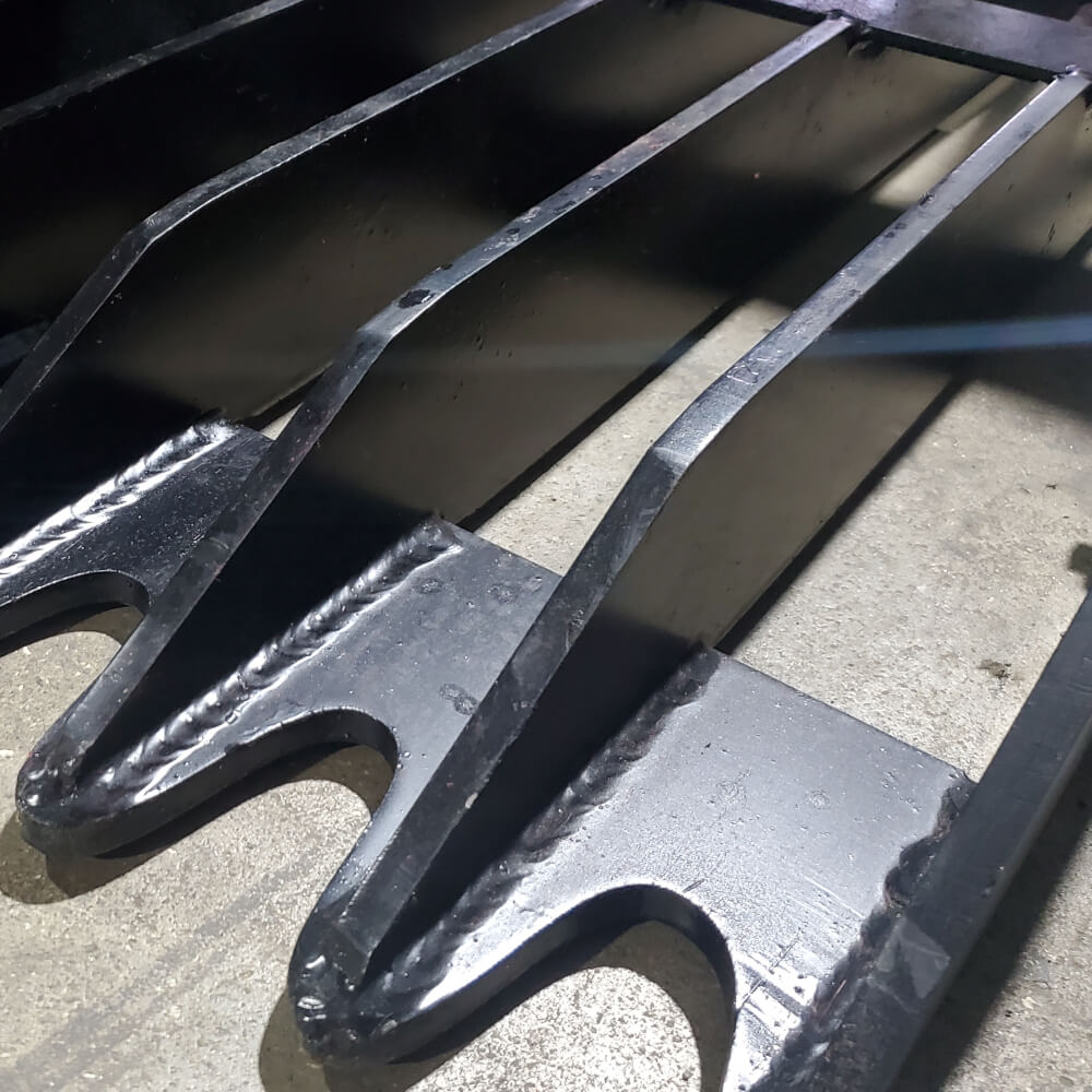 Rock and Brush Grapple by Glacier Attachments, angled view showcasing sharp, durable black tines.