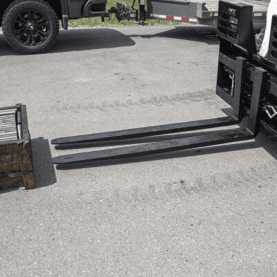 Prime Attachments Skid Steer Hydraulic Adjustable Forks, black, angled view with extended tines and attachment frame.