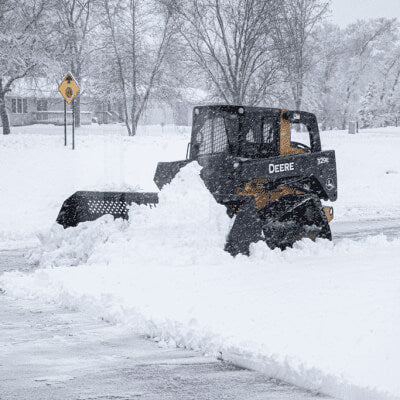 Skid Steer Snow Bucket — Prime Attachments, black with front mesh design, clearing snow.