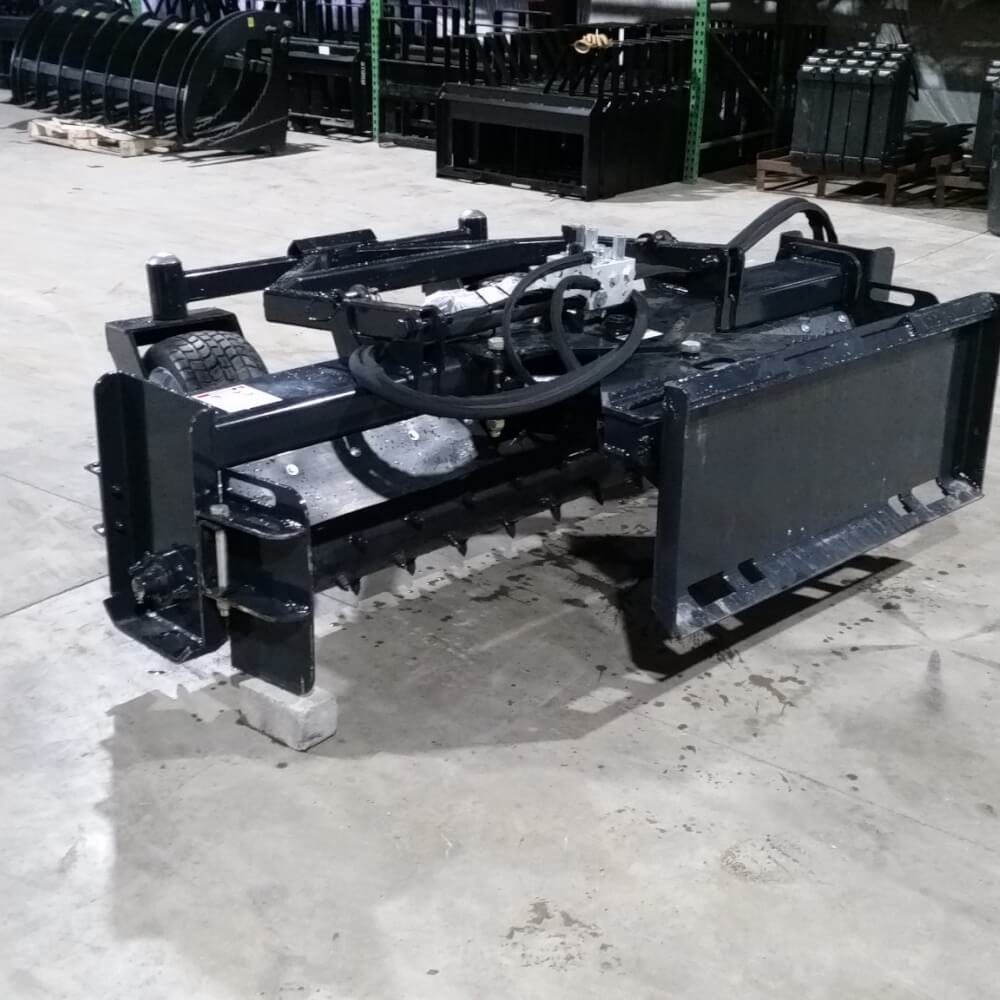 Skid Steer Soil Conditioner by Glacier Attachments, black with an angled design and tires.