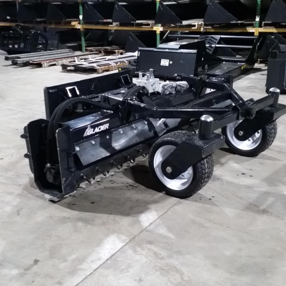 Glacier Skid Steer Soil Conditioner, black, angled view with wheels and hydraulic controls.