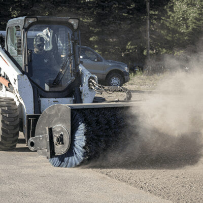 Prime Attachments Skid Steer Sweeper Attachment angled view, featuring a large blue bristle brush.