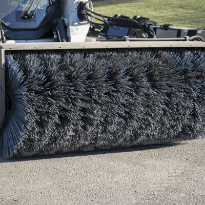 Skid Steer Sweeper Attachment by Prime Attachments, angled view with large bristle brush.