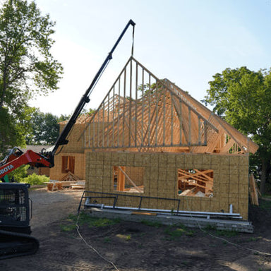 Skid Steer Teleboom by Prime Attachments, black, angled view with extended boom for construction.