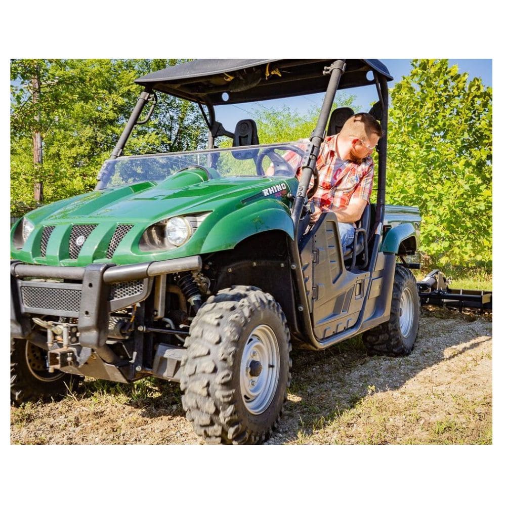 Swisher Commercial Pro RoadBuster Driveway Grader attached to green utility vehicle, showcasing heavy-duty wheels.