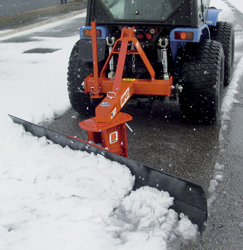 BEFCO 3 Point Rear Blade for Tractor, orange with a black blade, angled view clearing snow.