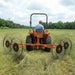 BEFCO RS2 V-Type Wheel Rake attached to tractor raking hay in the field.