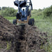 Backhoe for Skid Steer by Prime Attachments, angled view, black and yellow with digging arm.