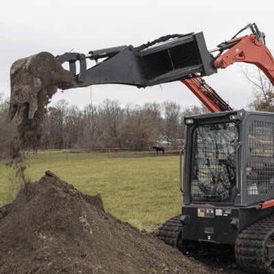 Backhoe for Skid Steer by Prime Attachments, angled view, featuring a robust digging arm and bucket.