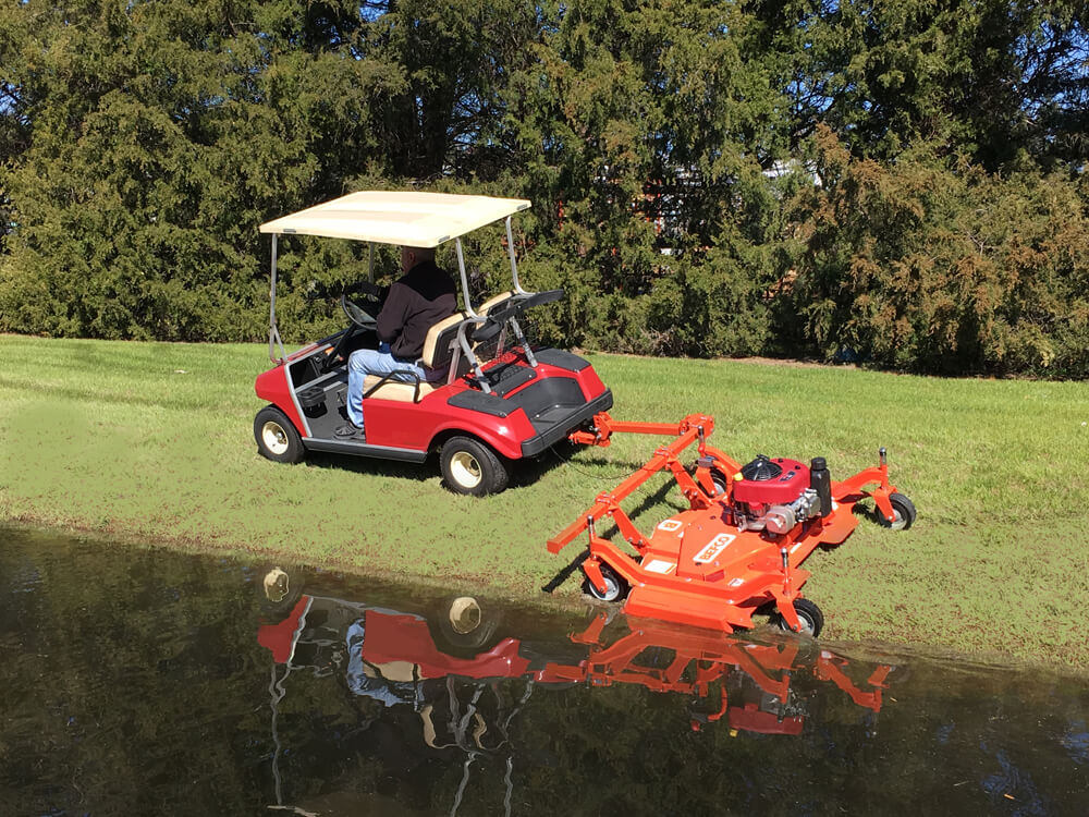 BEFCO Cyclone C30-CE5H grooming mower in orange, attached to a red golf cart, angled view.