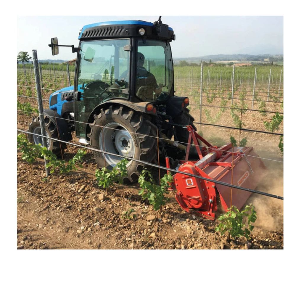 BEFCO T50 Rotary Tiller in red, attached to a tractor, working in a vineyard.