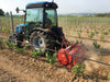 BEFCO T50 Rotary Tiller in red, attached to a tractor, working in a vineyard.