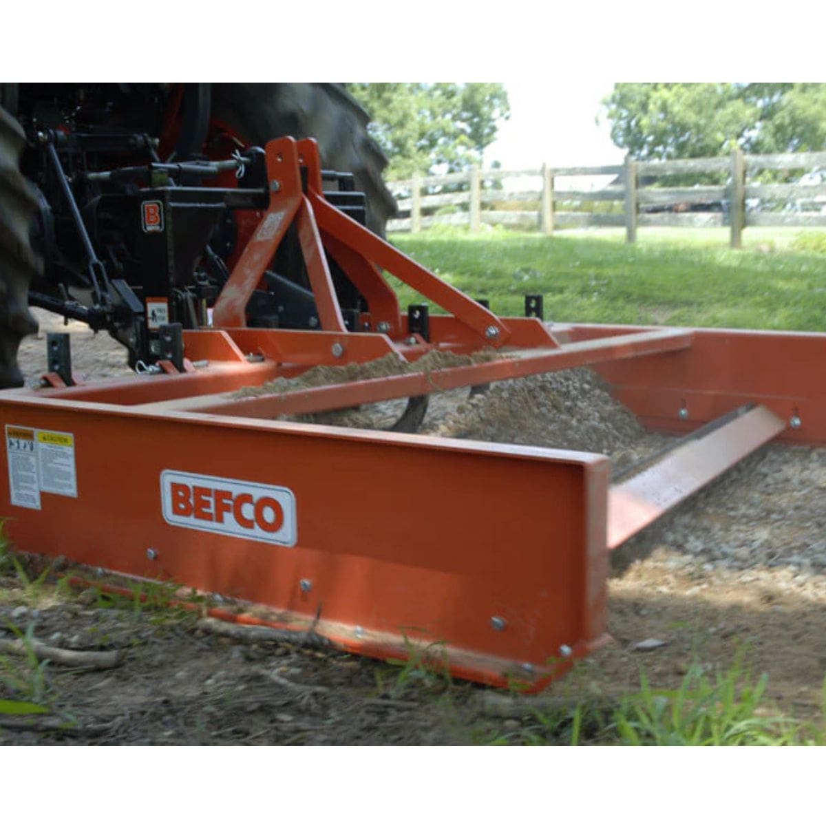 BEFCO Tractor Grading Scraper in orange, front view with adjustable grading blade and attachment.