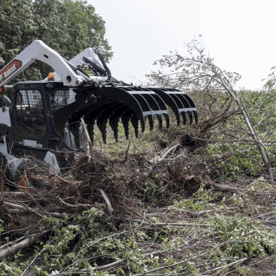 Prime Attachments Dual Clamshell Grapple for skid steer, black, angled view with multiple claws.