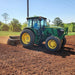 Firminator G3 - Disks and Cultipackers on a green tractor tilling brown soil under a clear sky.