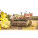 Firminator G3 - Disks and Cultipackers in action on a sunny field with operator adjusting soil preparation equipment.