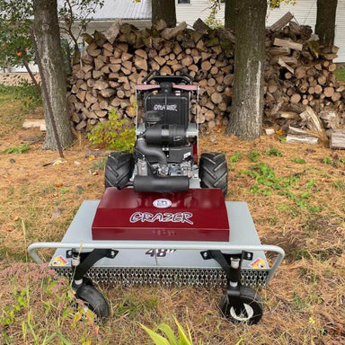 Grazer Brush Mower 24 HP Kawasaki front view, red and gray with oversized wheels and handles.