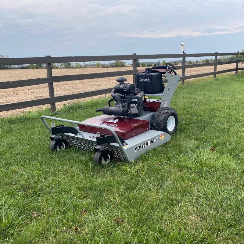 Grazer Brush Mower 24 HP Kawasaki in red and gray, angled view with large wheels and engine.