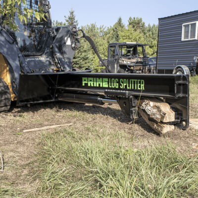 Prime Attachments Inverted Log Splitter for Skid Steer, black with green logo and wood logs.