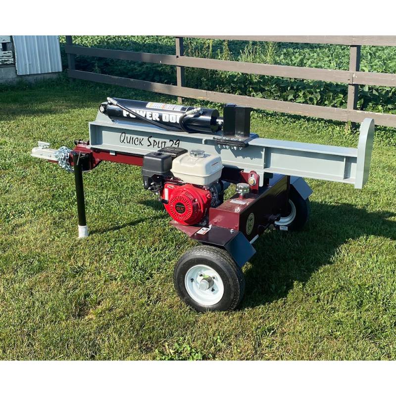Power Dog Quick Split log splitter angled side view with Honda engine on grassy yard.