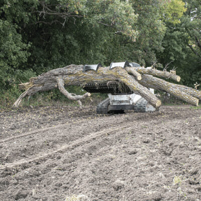 Rock and Brush Grapple by Prime Attachments, angled view, featuring a sturdy grasp on large logs.