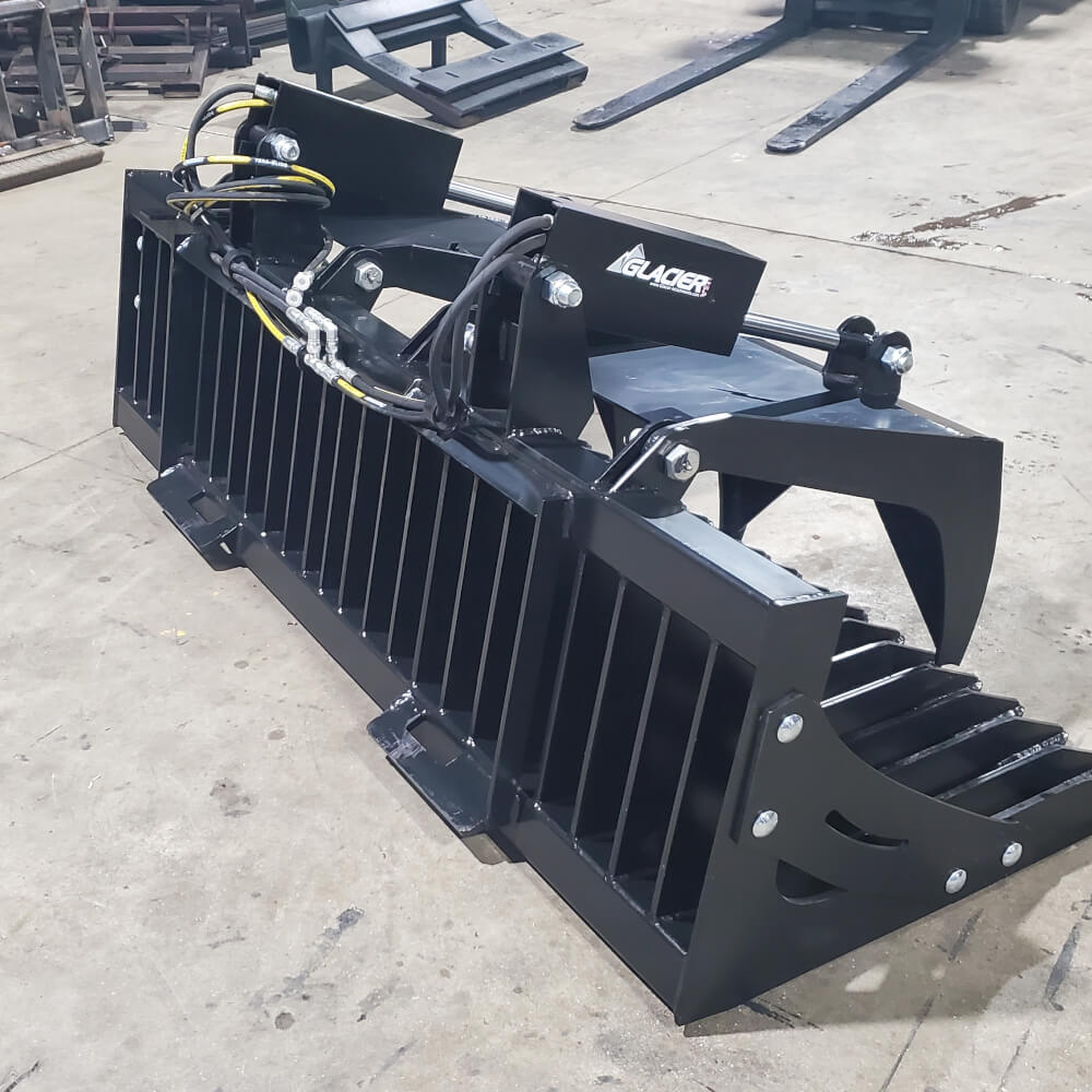 Rock and Brush Grapple by Glacier Attachments, black, angled view, with hydraulic hoses and teeth.