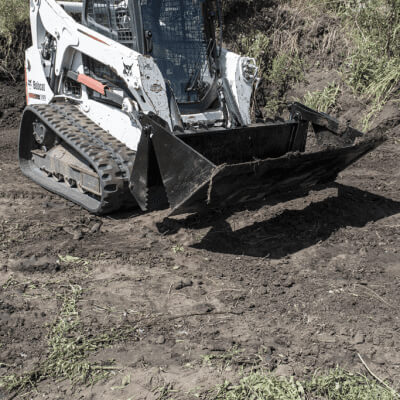 Skid Steer 4-in-1 Bucket by Prime Attachments, angled view, black with rugged cutting edges.