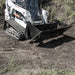 Skid Steer 4-in-1 Bucket by Prime Attachments, angled view, black with rugged cutting edges.