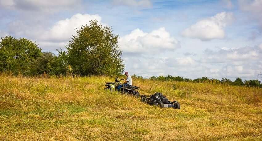 Swisher 44 Commercial Pro Rough Cut Mower, angled view, black, featuring large wheels and durable cutting deck.
