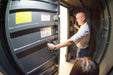 Swisher 6 Person ESP Safety Shelter, gray industrial design with a secure door mechanism.