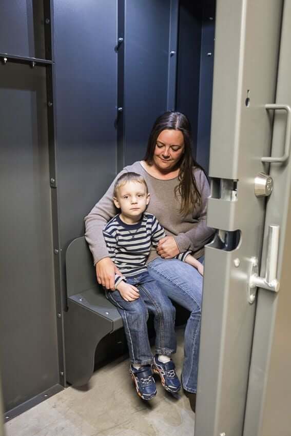 Swisher 6 Person ESP Safety Shelter interior view, featuring gray walls and seating.