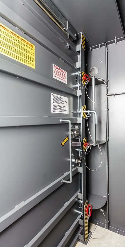 Swisher 9 Person ESP Safety Shelter interior view, featuring gray walls and safety harness attachments.