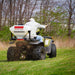 Swisher Commercial Pro ATV Spreader, rear view with white hopper and spreading feature in action.