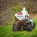 Swisher Commercial Pro ATV Spreader, white and red, mounted on ATV, dispersing material.