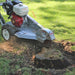 Dosko 337 walk-behind stump grinder cutting a tree stump from rear side view